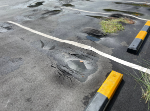 damaged parking lot with potholes